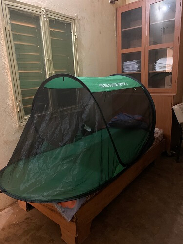 Mosquito net tent on a twin bed in Africa.